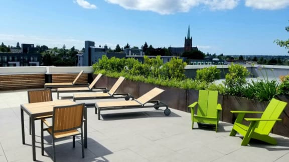 A patio with green chairs and a table.