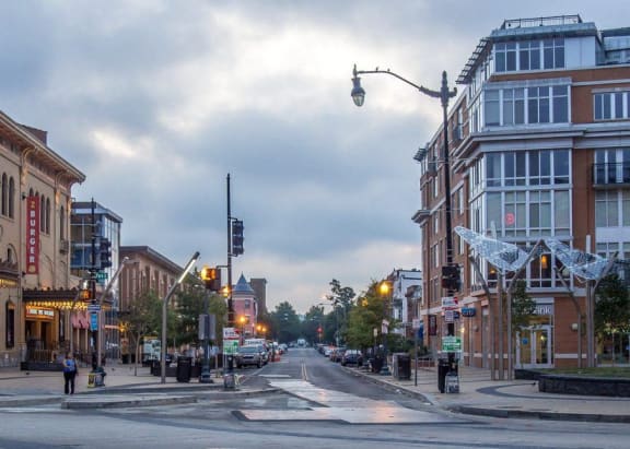 a city street with people and buildings on a cloudy day