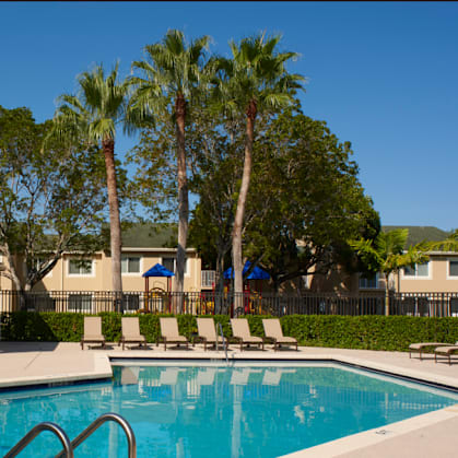 A pool surrounded by white chairs and a white fence. at The Regency, Manassas, Virginia