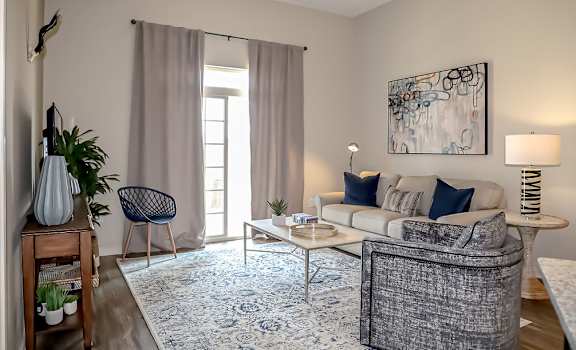 a living room with a couch and a table at The Station at River Crossing, Macon, GA