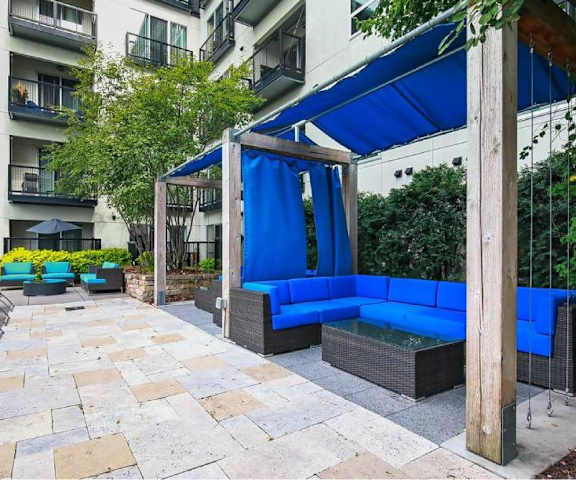 The courtyard of Blue and Lime Apartments with blue chairs and couches. 