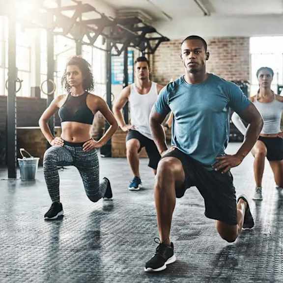a group of people running in a gym