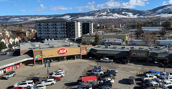 A parking lot with cars and a liquor store in the background.