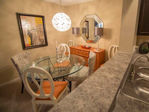 A kitchen with a granite countertop and a glass table.