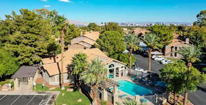 an aerial view of a house with a pool and palm trees