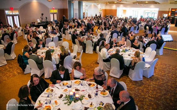 a large group of people sitting at tables in a banquet hall