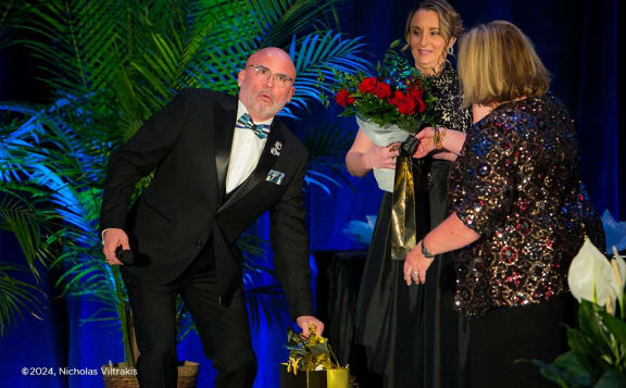a man in a suit and tie and a woman holding a bouquet of flowers