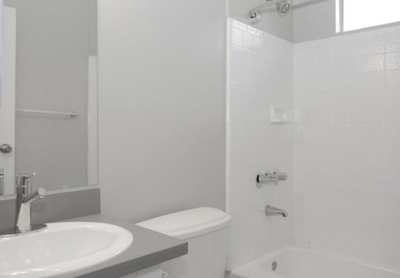 a white bathroom with a sink and a toilet  at The Marq Apartments LLC, Los Angeles