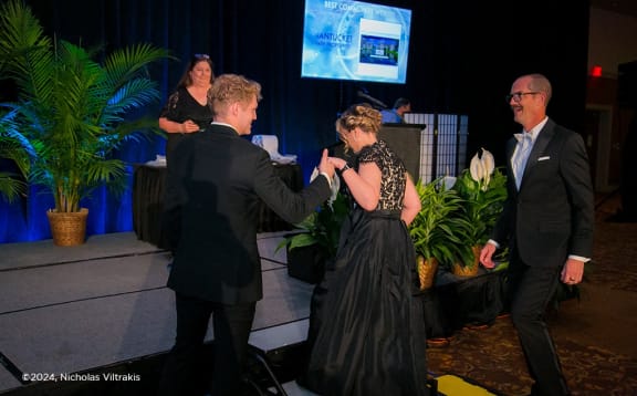 a group of people standing on a stage shaking hands