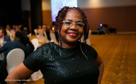 a woman wearing glasses smiles at the camera