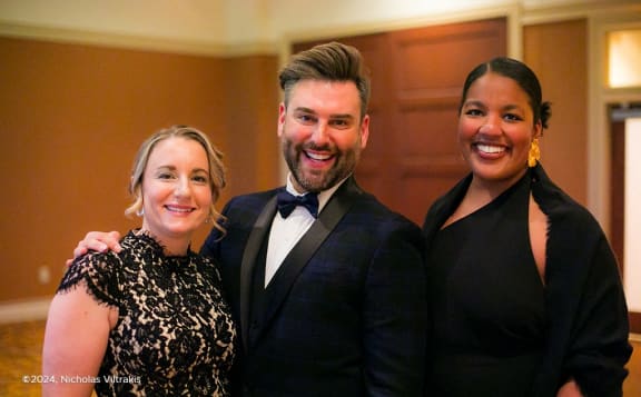 a man in a suit and two women posing for a picture