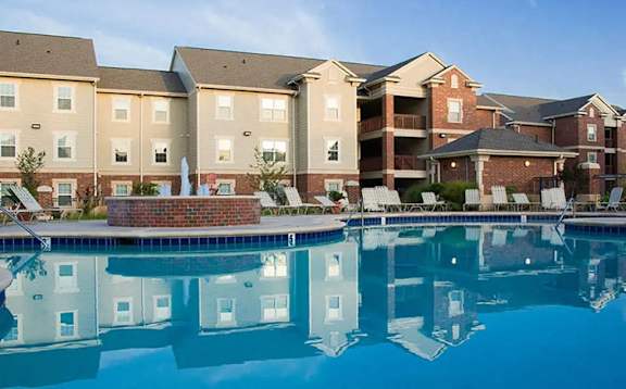 a swimming pool with apartment buildings in the background