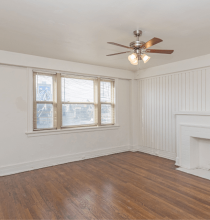 a living room with a fireplace and a ceiling fan