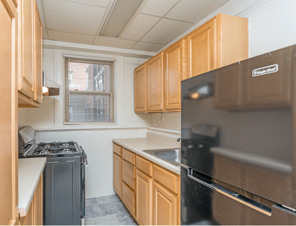 a kitchen with wooden cabinets and a stove and refrigerator