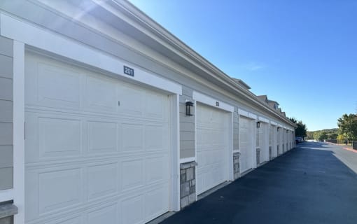 a row of white garage doors on a building
