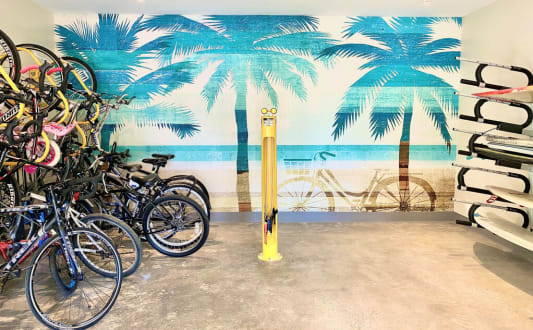 a group of bikes parked in front of a wall mural of a beach with palm at La Jolla Blue, San Diego, CA
