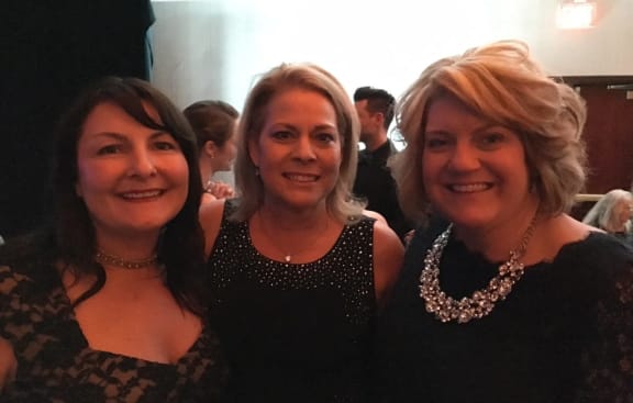 three women posing for a picture at a party