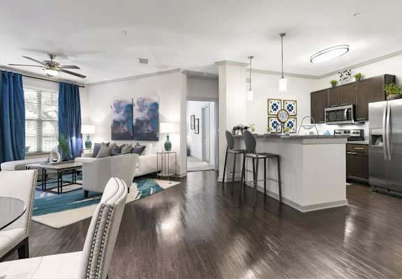 Open concept kitchen area with kitchen island, stainless steel appliances, white walls and vinyl wood flooring