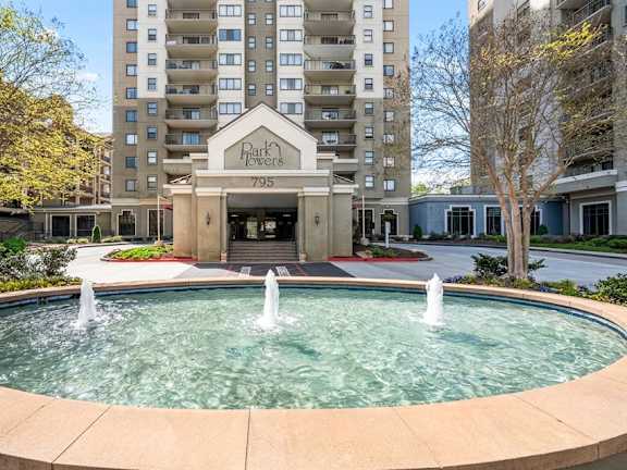 A fountain in front of a building with the number 795 on it.