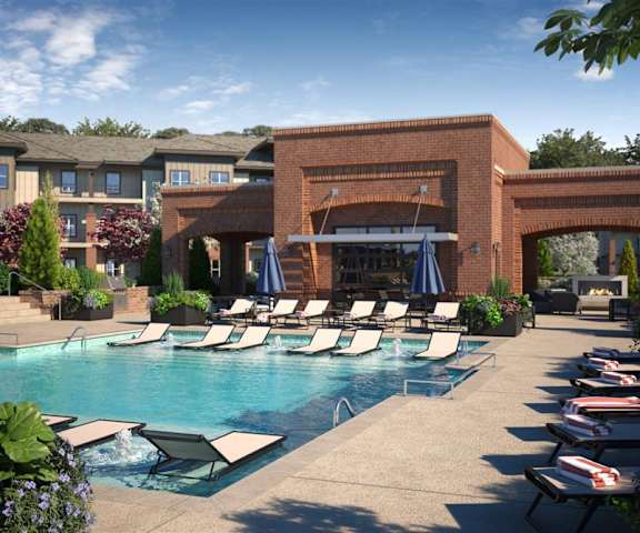 Outdoor Pool at 71 Tulsa Hills with chairs in and out of the pool with plants surrounding them. 