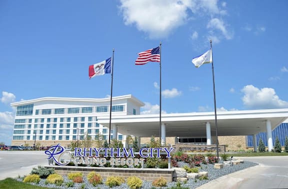 The Rhythm City Casino Resort is a large building with a flagpole displaying the American flag. at Deer Valley Apartments, Illinois