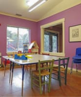 a play room with an activity table and chairs and a sliding glass door at Troutdale Terrace, Troutdale, OR
