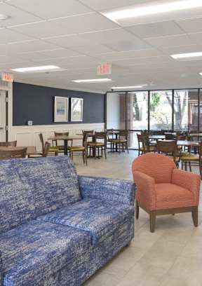a room with a couch chairs and tables in it