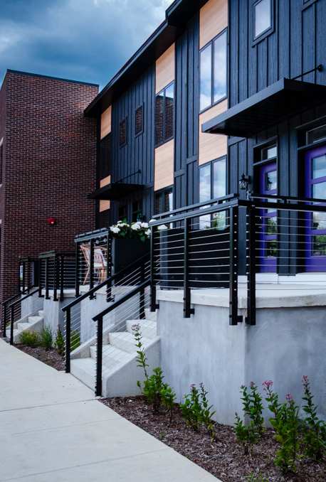 A modern building with a black railing and a white wall.