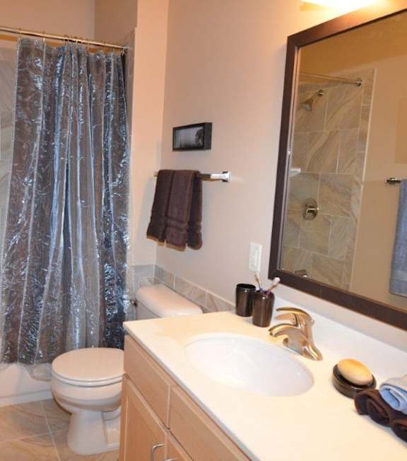 A bathroom with a white toilet, a white sink, and a shower.
