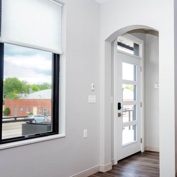 A white door with a glass window is open.