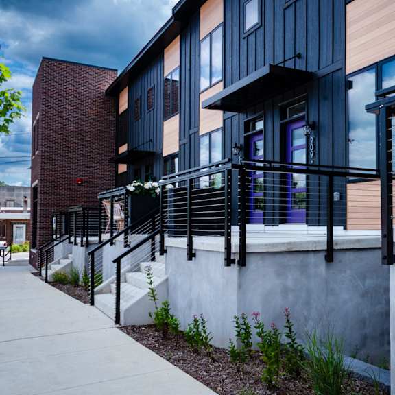 A modern building with a black railing and a white wall.