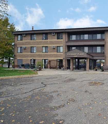 A large building with the words "Pleasant Place" on the front.