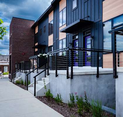 A modern building with a black railing and a white wall.