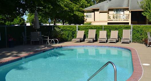 A pool with a red border and a metal ladder.