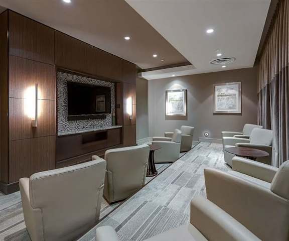 A resident lounge with tables, chairs, and a TV at Cityplace Heights. 