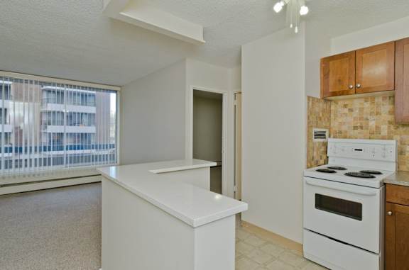 A kitchen with a white stove and a white counter.