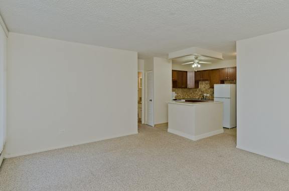 A white room with a kitchen area in the background.