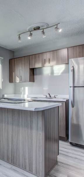 A kitchen with a large window and a refrigerator.at Tigardville Apartments, Tigard Oregon