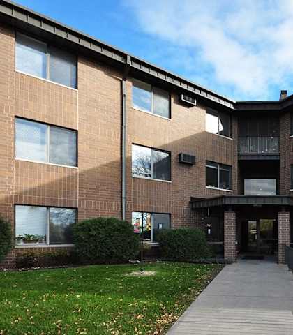 A brick building with a walkway leading to the entrance.