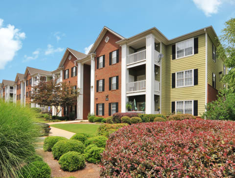 Exterior of apartment with a grass area and flower bed by the building