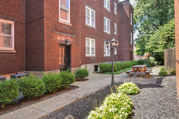 a courtyard with a picnic table in front of a brick building