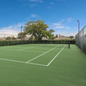 a tennis court with white lines on a green court at Seacrest Apartments, Garland, Texas