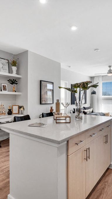 a white kitchen with a large island in the middle