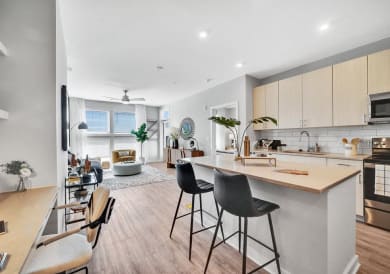 an open kitchen and living room with a bar and stools