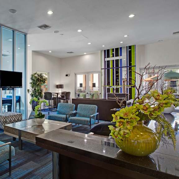 The community clubhouse, complete with plush chairs, coffee tables, and TVs at Aspire Pinnacle Peak. 