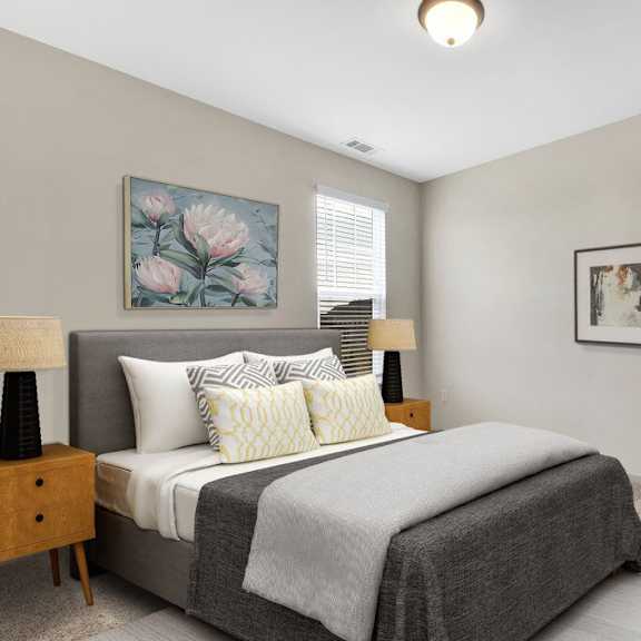 A bedroom with a bed, nightstand, and two lamps.