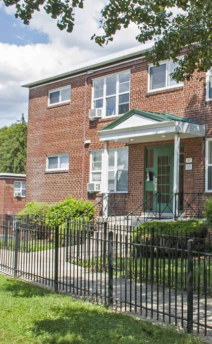 a red brick building with a wrought iron fence in front of it