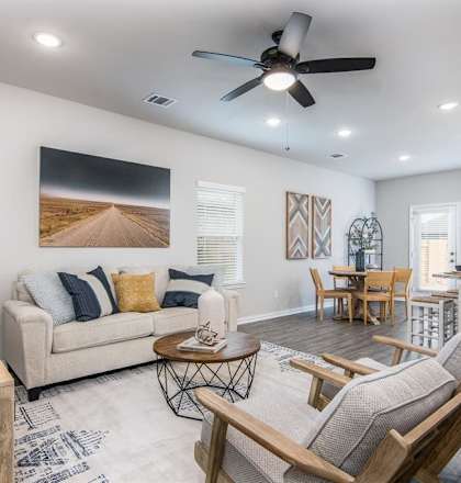 a living room filled with furniture and a ceiling fan