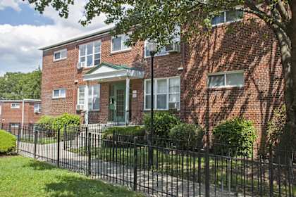 a red brick building with a wrought iron fence in front of it