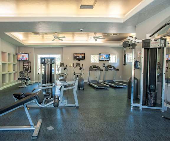 A gym with weights and cardio equipment in a large room at Artisan 8282. 